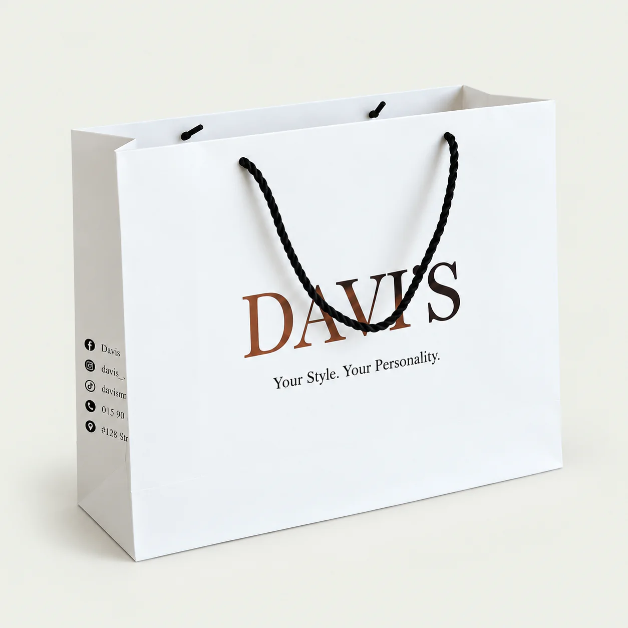 Three-quarter view of a white paper bag with black twisted rope handles.