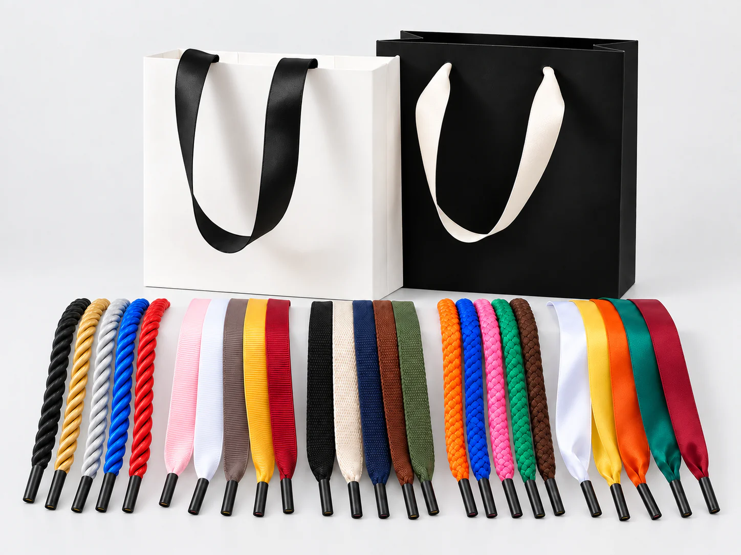 Handles & Attachments guide overview Black and white paper bags displayed behind rope, woven and ribbon handle samples.