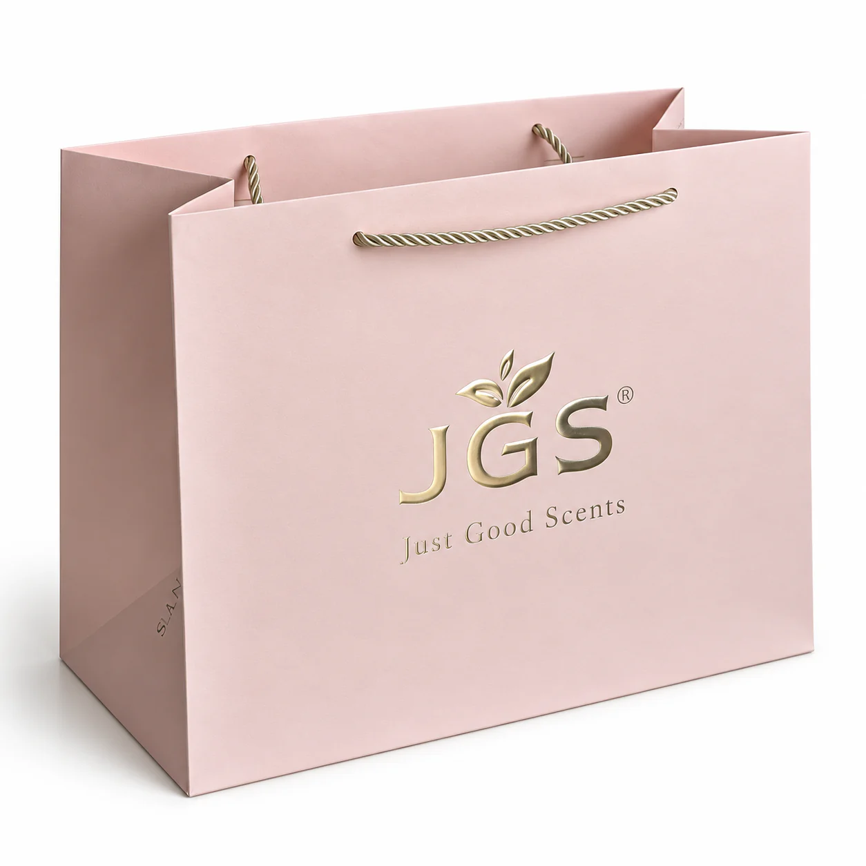 Three-quarter view of a pale pink paper bag with gold twisted rope handles and matching metallic artwork.
