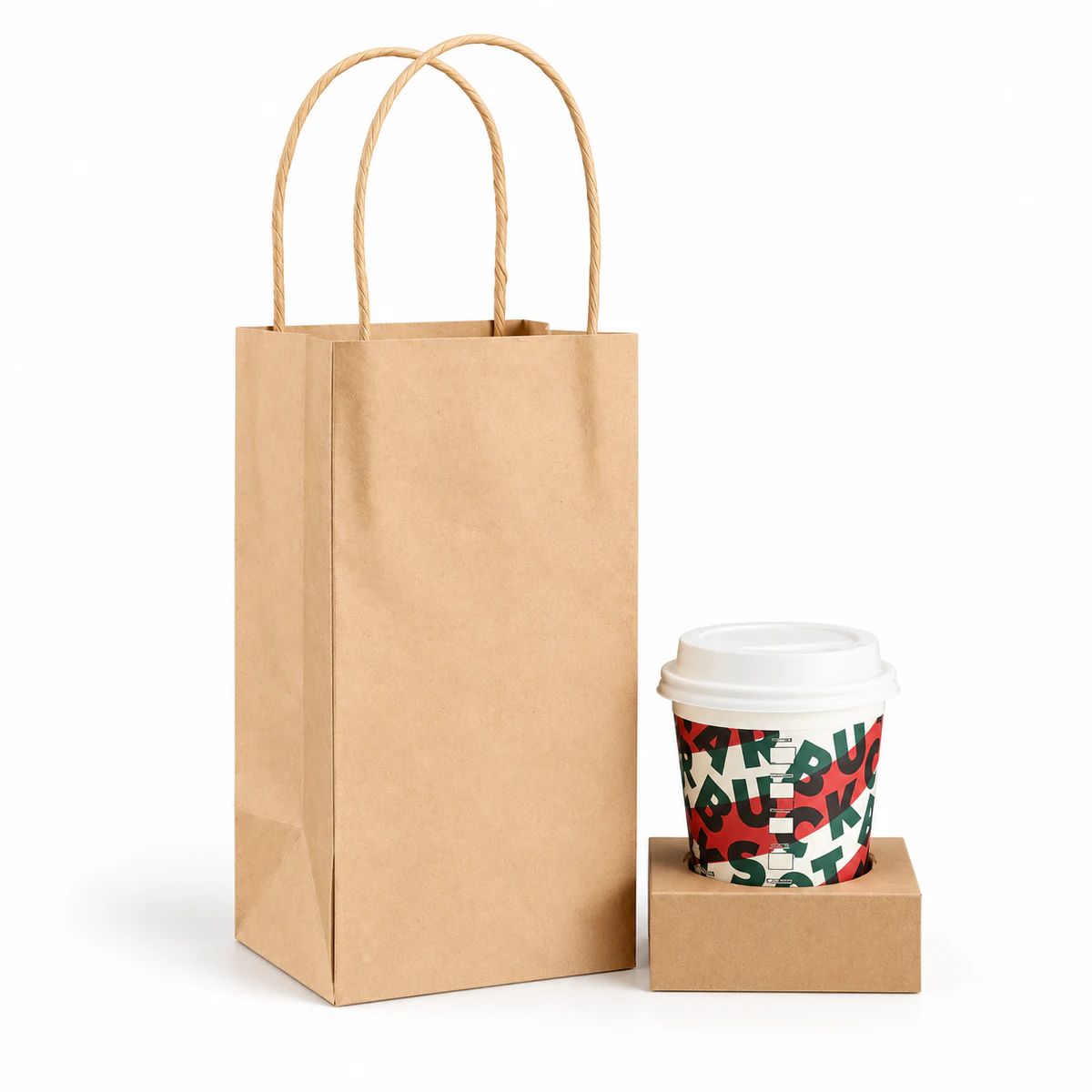 A narrow kraft paper bag beside a lidded cup in a single-cup cardboard holder.
