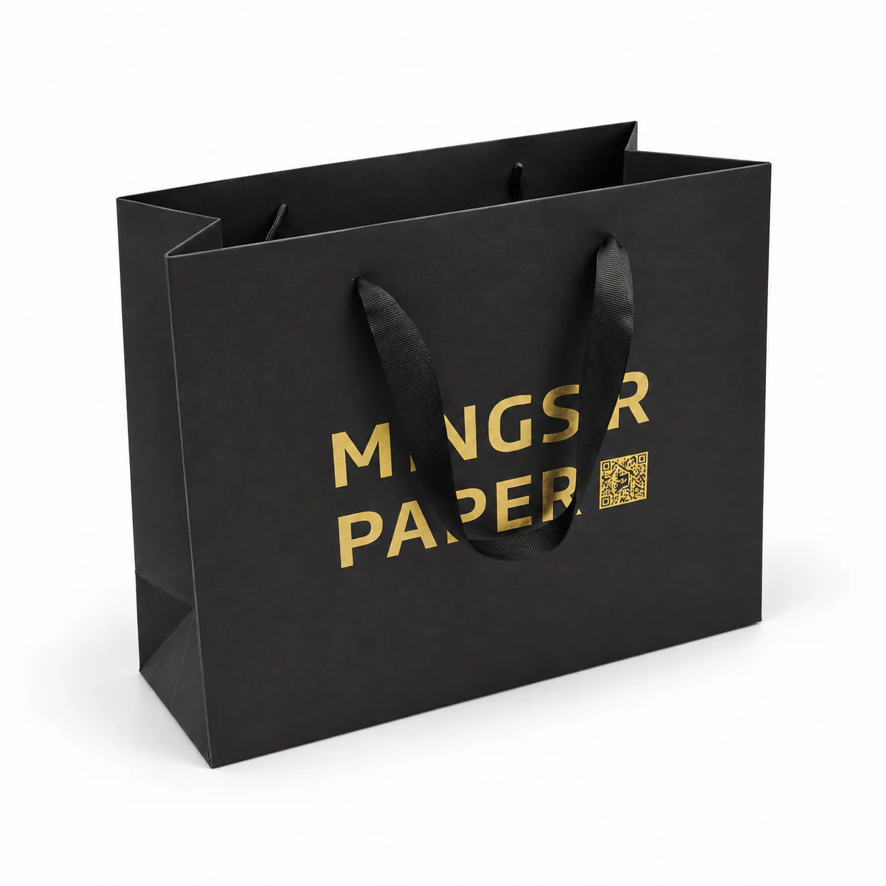 Three-quarter view of a black paper bag with black threaded ribbon handles and metallic gold artwork.