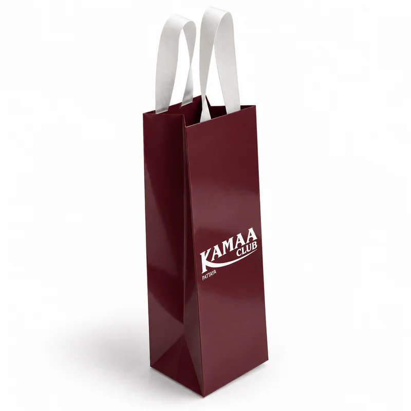 Tall burgundy wine paper bag with white ribbon handles attached inside the top.
