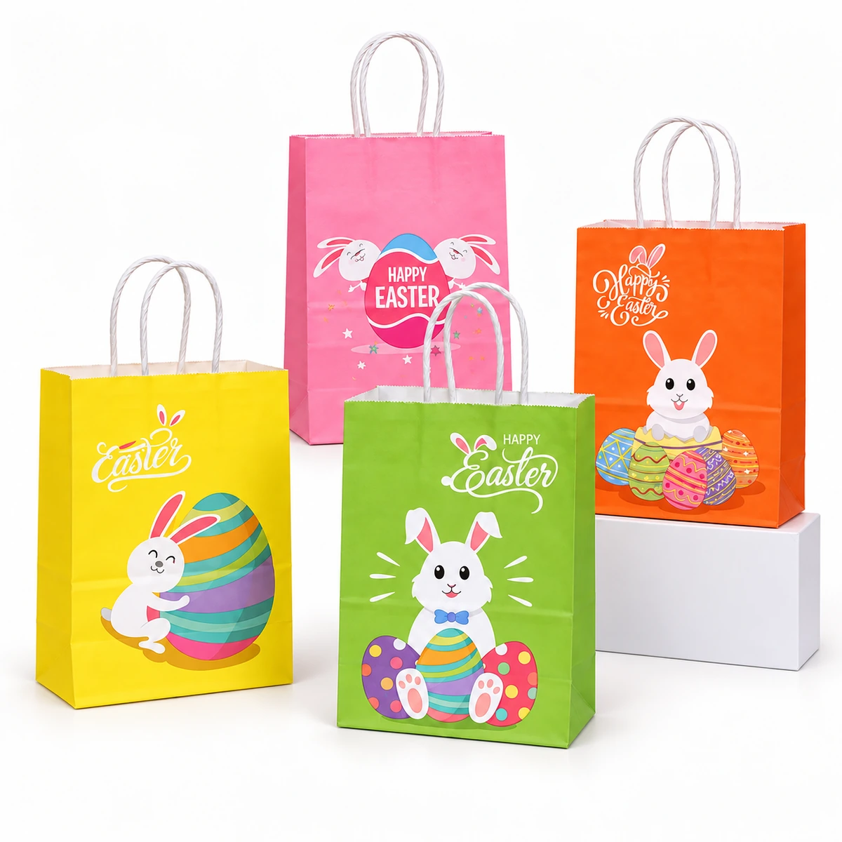 Four Easter paper gift bags in yellow, pink, green and orange with rabbit and decorated egg illustrations and white loop handles