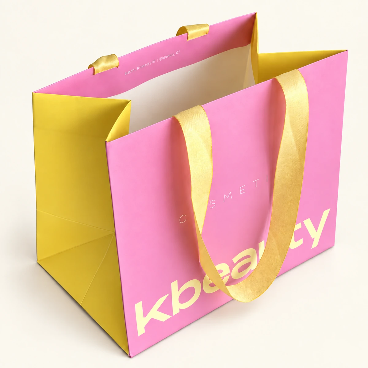 Pink and yellow paper bag with wide yellow ribbon handles