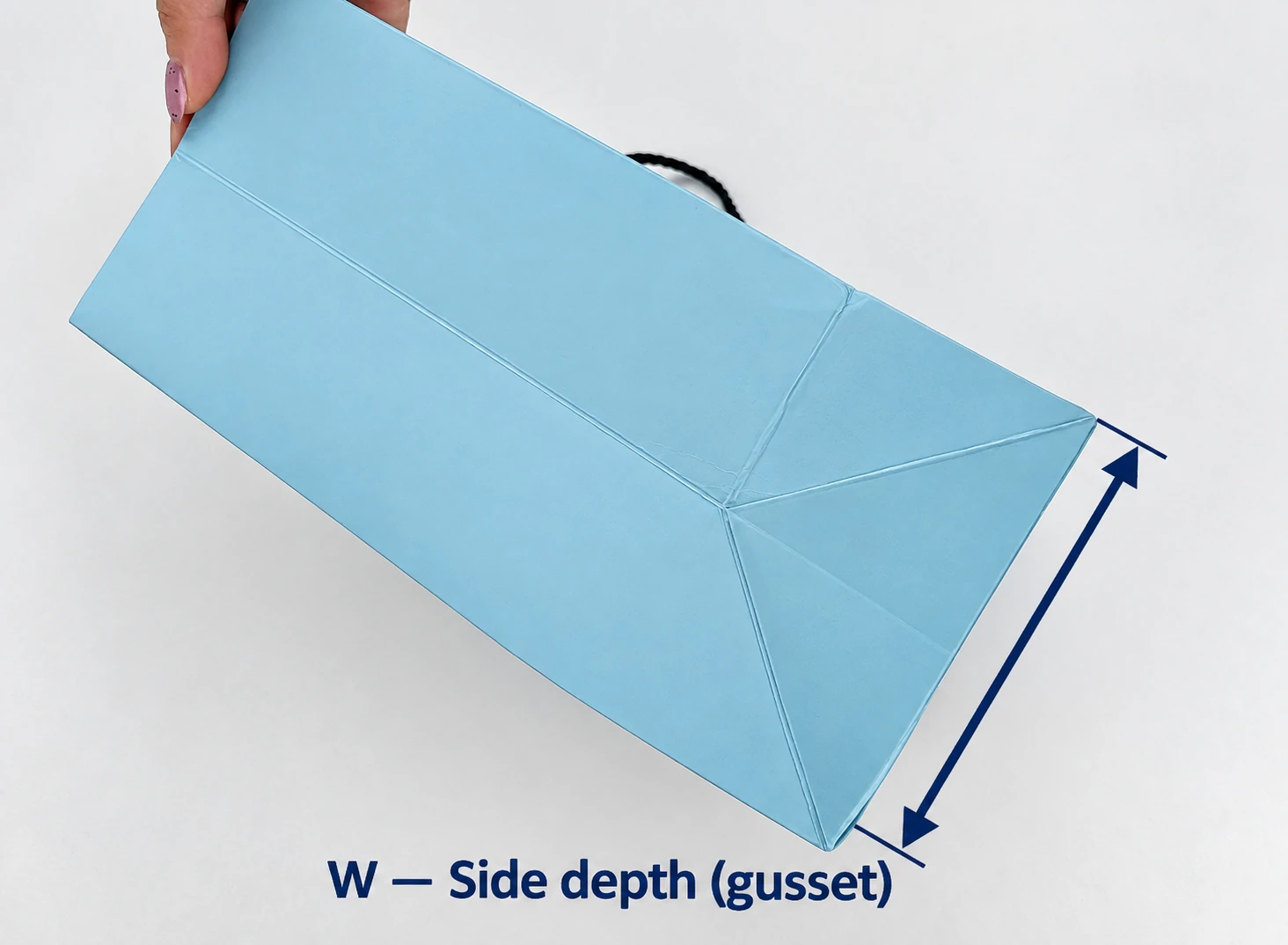 Underside of a blue paper bag with an arrow across the short bottom edge showing the full side depth