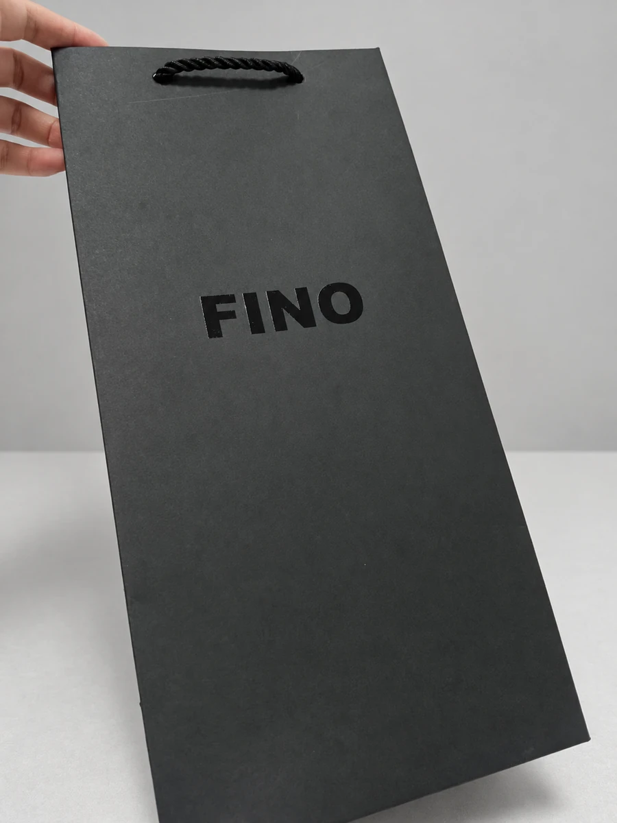 Dark grey paper bag with a glossy black FINO wordmark and a black rope handle