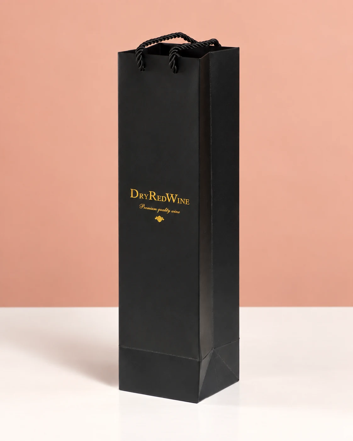 A tall black wine paper bag with gold-coloured lettering and black cord handles.