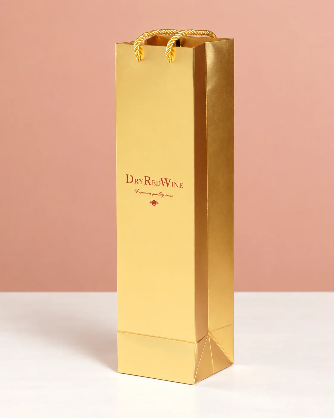 A gold-coloured wine paper bag with red lettering and gold-coloured cord handles.