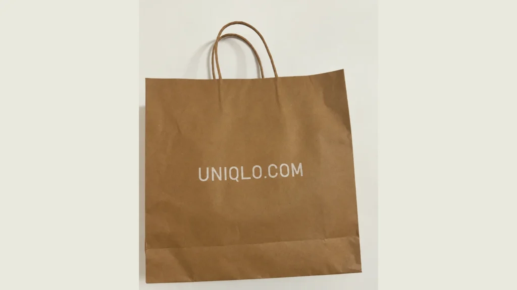 Brown kraft shopping bag with paper handles and a soft white UNIQLO.COM logo