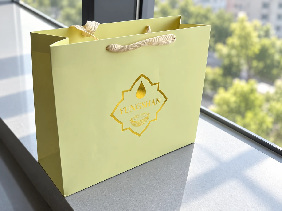 YUNGSHAN gold foil outline and lettering on a pale yellow-green paper bag with woven handles