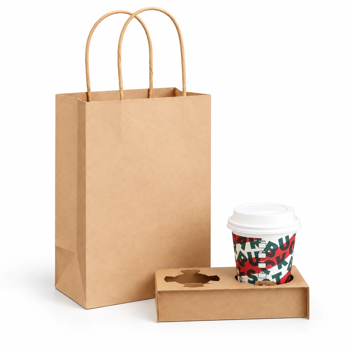 A kraft paper bag beside a rectangular two-position cardboard carrier with one lidded printed cup and one empty opening.