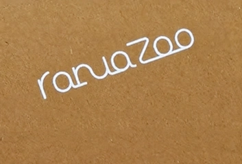 Thin white ranuaZoo lettering printed diagonally on brown kraft paper