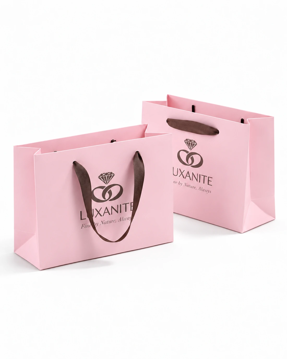 Two pink jewelry paper bags with brown ribbon threaded through the upper front panels