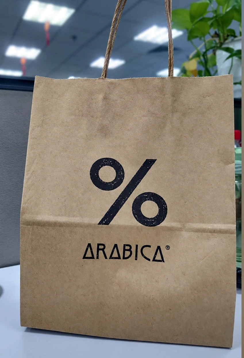 Brown Arabica paper bag with a large black percentage symbol and ARABICA lettering beneath it
