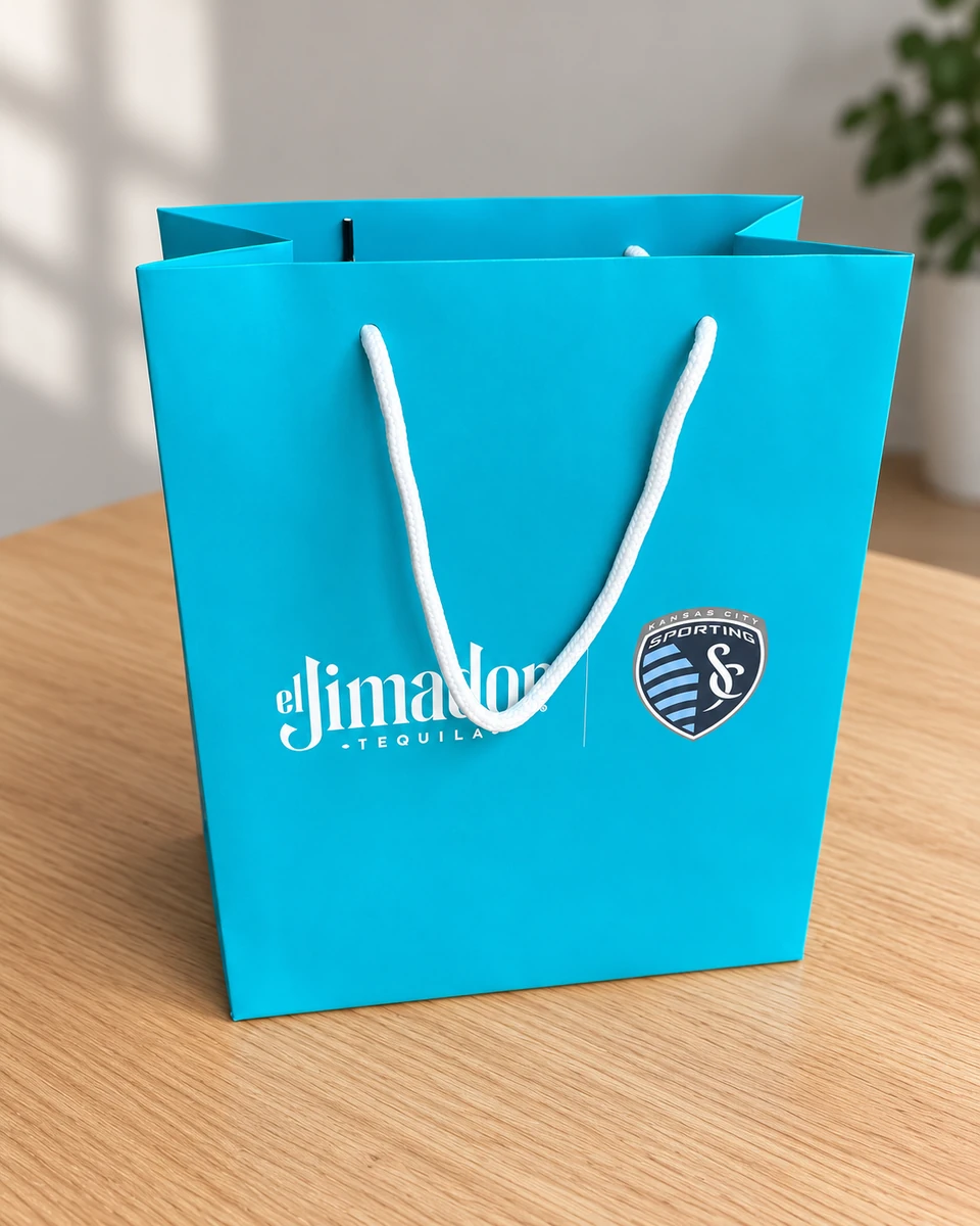 Blue shopping bag with white threaded cord handles and el Jimador and Sporting logos